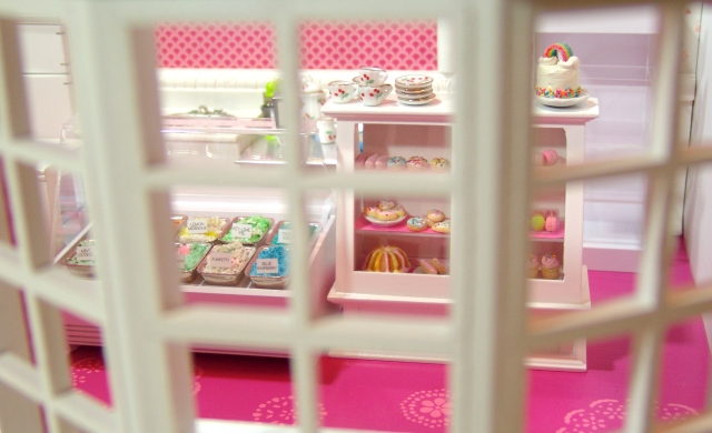 Peeking through the window of a miniature bakery by The Mouse Market.